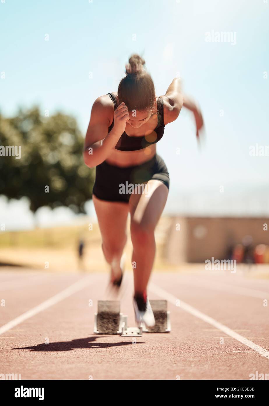 Läuferin, Wettkampf- und Athletenleistung, Kraft- und Cardio-Fitness auf der Stadion-Laufstrecke. Bewegungsunschärfe beim Marathon-Sporttraining auf Stockfoto