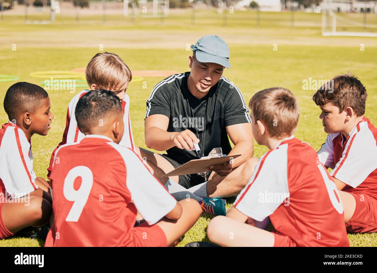 Teamarbeit, Coaching und Fußball mit Kindern auf dem Feld für Training, Fitness und sportliche Ziele. Planung, Pitch und Strategie mit Mentor und Fußball Stockfoto