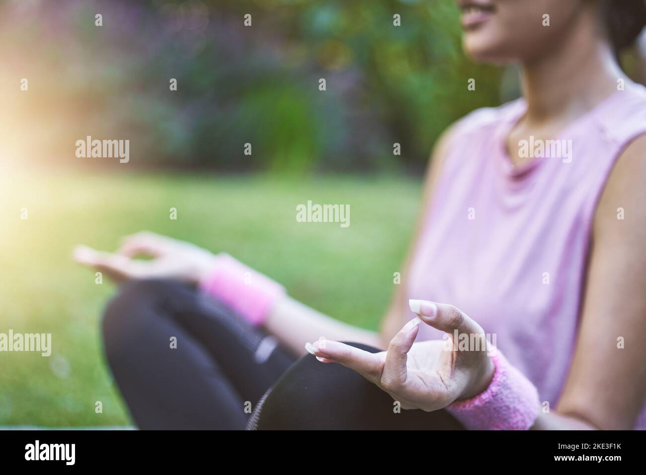 Hände, Meditation und Fitness mit einer schwarzen Sportlerin, die auf einem Grasfeld sitzt, um Zen oder Wellness zu machen. Yoga, Natur und meditieren mit einem weiblichen Yogi Stockfoto