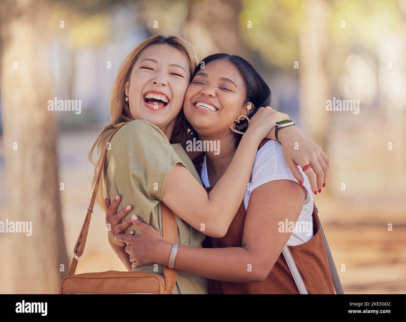 Frauen, Freunde und glückliche Umarmung in der Sonne im Freien mit Umarmung, Liebe und Lächeln im Sommer für den Urlaub. Vielfalt, asiatische Frau und schwarze Frau mit Stockfoto