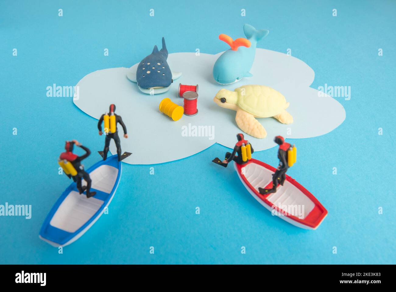 Miniaturspielzeug - Draufsicht giftige Abfälle, die ins Meer geworfen wurden, führten zur Zerstörung von Meeresleben und zum Konzept der Meeresverschmutzung. Stockfoto