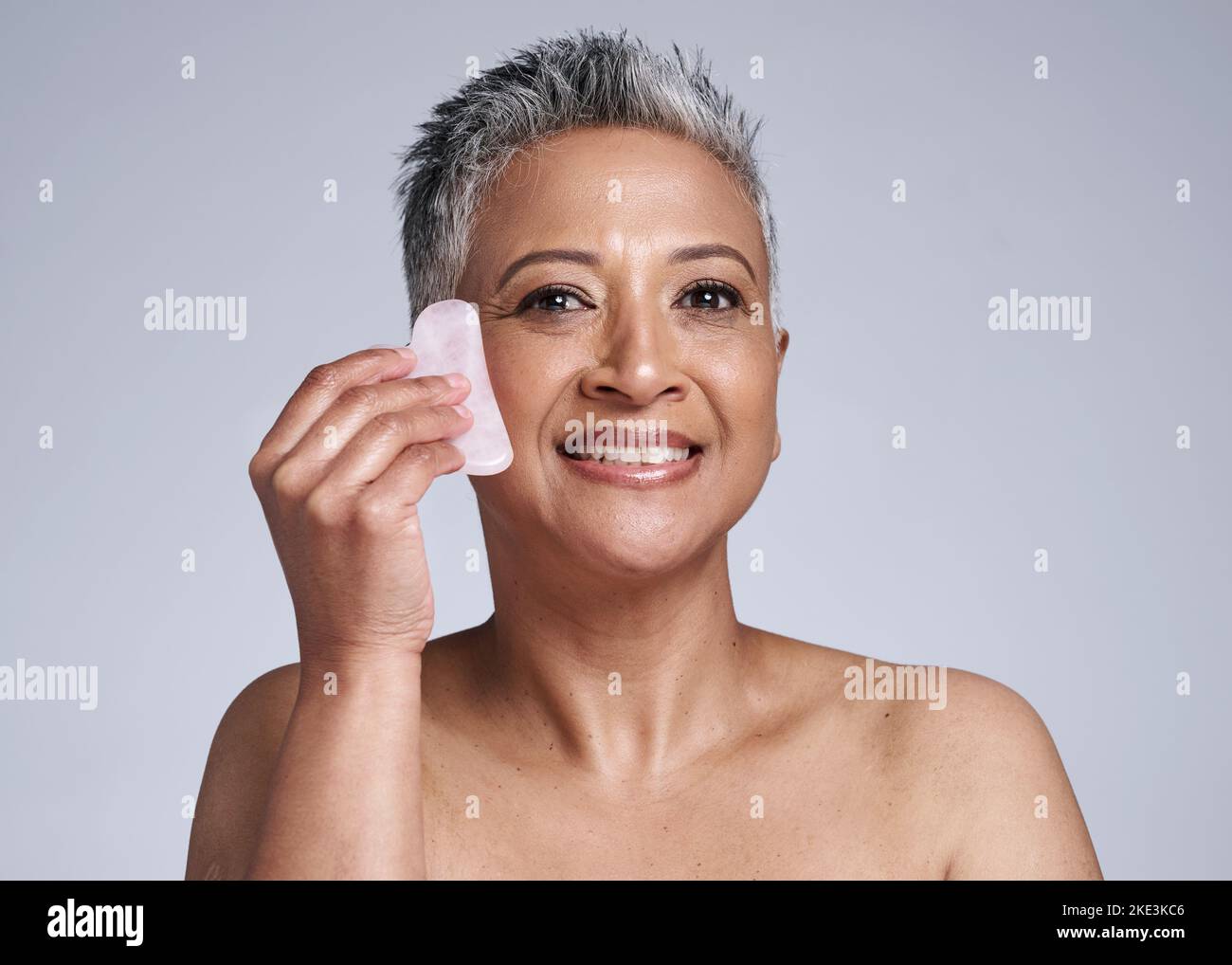 Ältere Menschen, Frau und Portrait der Massage mit Gua Sha Stein für Wellness, Durchblutung und Schönheit. Hautpflegemodell massiert Gesicht mit natürlichen Kristall für Stockfoto