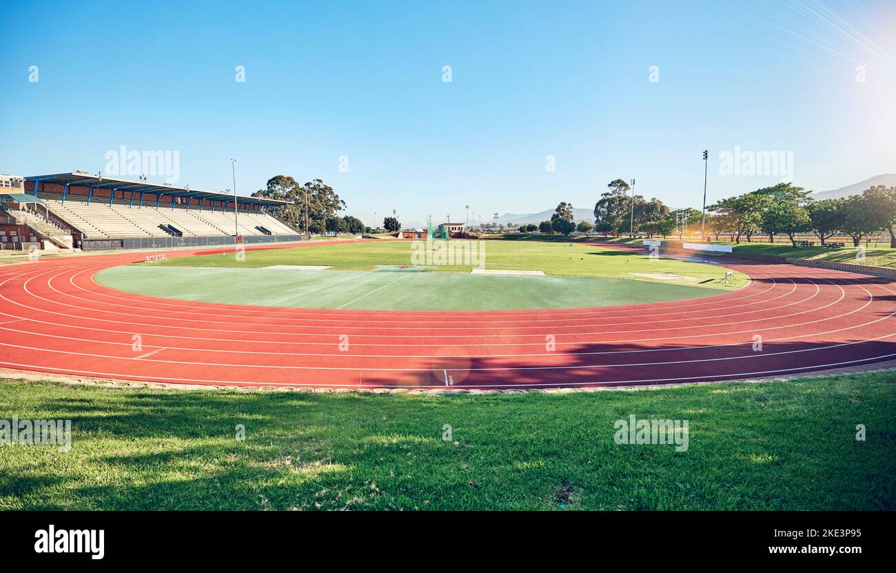 Sport-, Fitness- und Stadionstrecke zum Laufen, Outdoor- und Übungslandschaft, blauer Himmel und Gras. Aktiv, Trainingsmotivation und Laufen für ein gesundes Leben Stockfoto