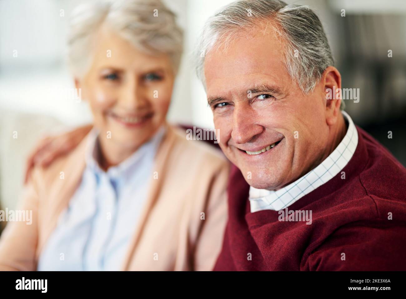 Und wir lebten glücklich immer danach...Porträt eines älteren Paares, das zu Hause zusammen saß. Stockfoto