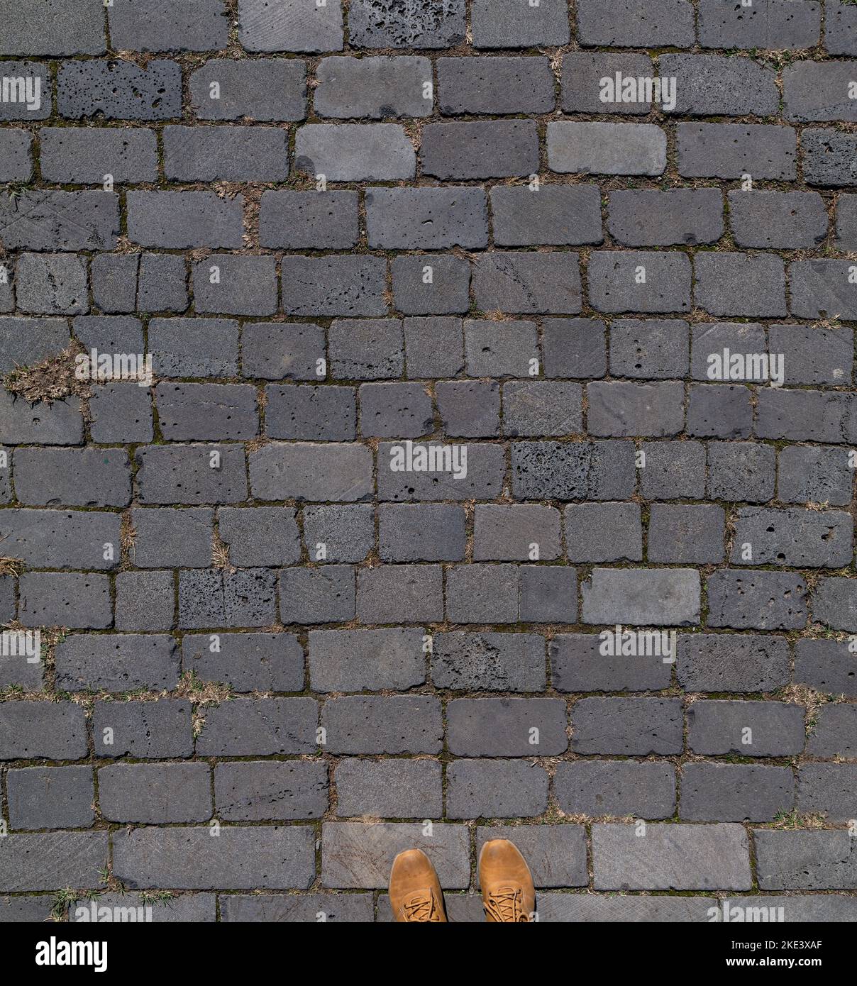 Alte Pflasterplatten mit Schuhen Stockfoto
