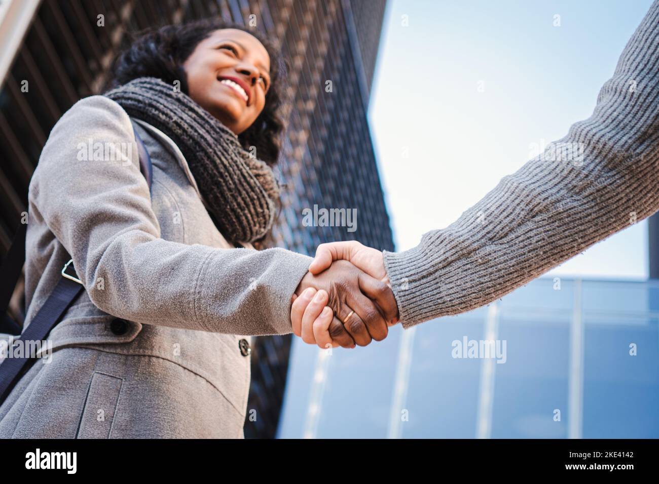 Eine Geschäftsfrau, die einen Händedruck abgab und lächelte, beendete ein erfolgreiches Meeting. Grußkonzept. Stockfoto