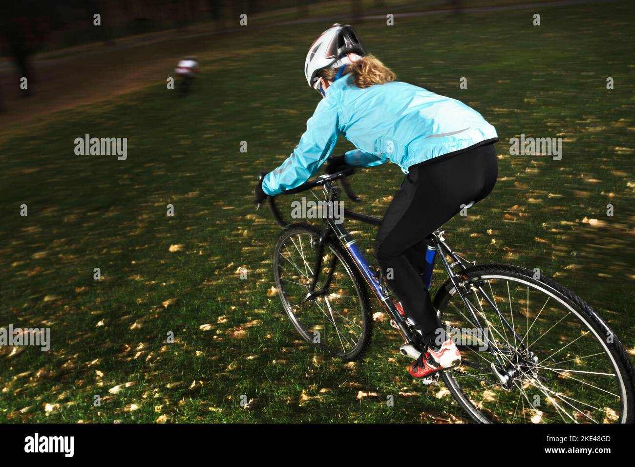 Weibliche Sportlerin trainiert an einem kalten bewölkten Tag für ein Herbstcyclocross-Rennen. Stockfoto