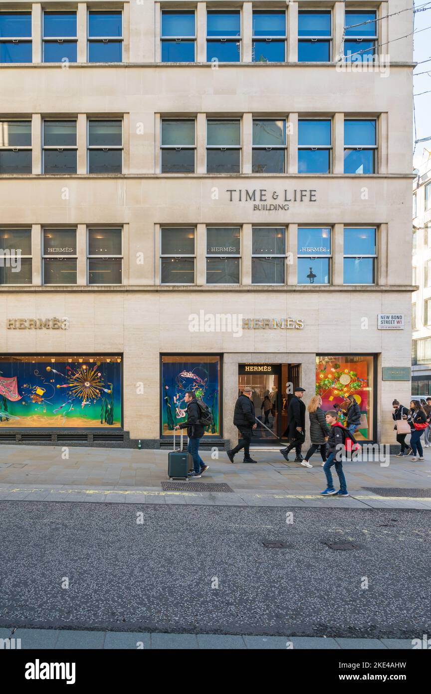 Die Leute kommen am Hermès-Laden vorbei, einem High-End-Händler für Luxuskleidung, Handtaschen, Tücher und Accessoires. New Bond Street, London, England, Großbritannien Stockfoto