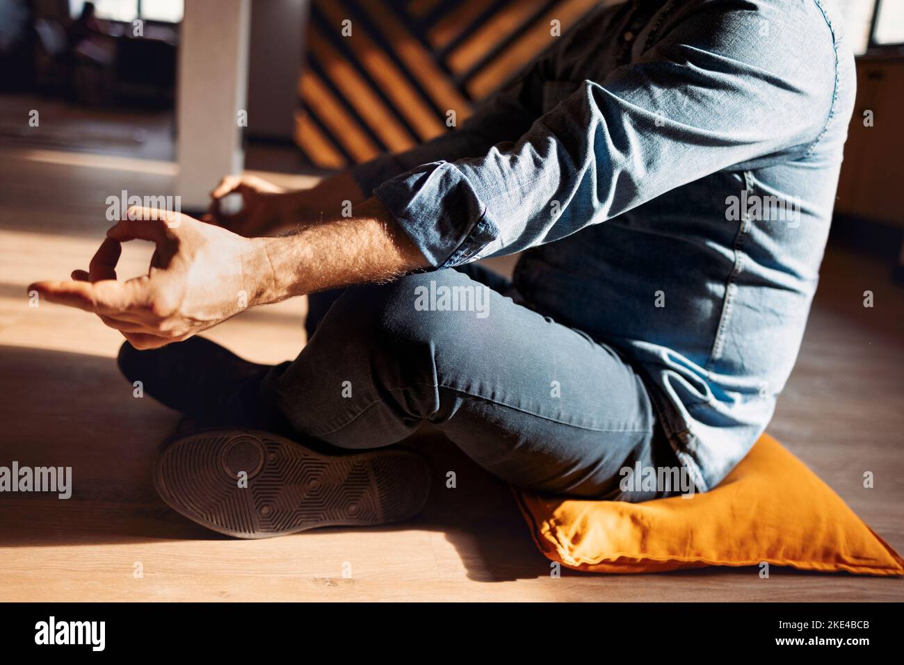 Gutaussehender hispanischer Mann trägt Jeans Casual Shirt sitzt auf dem Boden zu Hause entspannen, Meditation Geste mit den Fingern zu tun. Yoga-Konzept Stockfoto