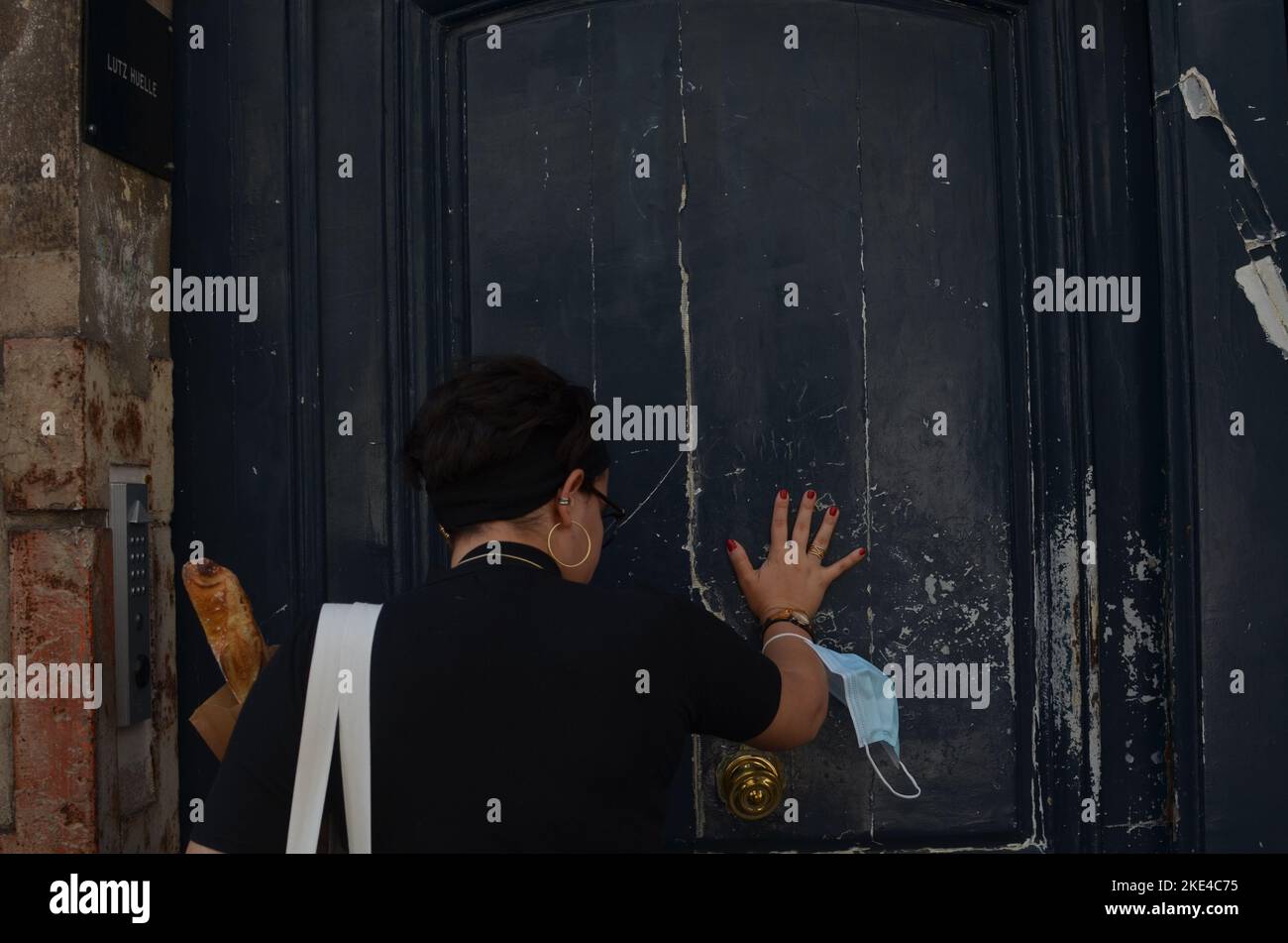 Eine schicke junge Frau, die die Tür zu ihrer Pariser Wohnung öffnet Stockfoto