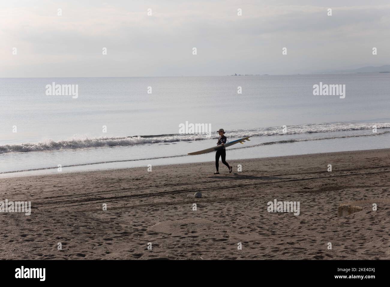 Enoshima, Japan. 28. Oktober 2022. Als Surferin, die mit ihrem Brett am Strand von Enoshima gesehen wird, ist Enoshima Beach ein beliebtes Ausflugsziel für alle Altersgruppen in Japan, mit dem Enoshima Aquarium als einer seiner größten Attraktionen. (Foto: Stanislav Kogiku/SOPA Images/Sipa USA) Quelle: SIPA USA/Alamy Live News Stockfoto