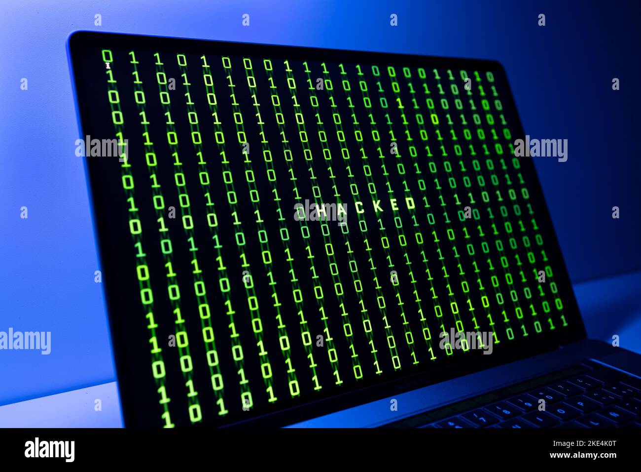Computer-Hacked-Konzept. Laptop-Bildschirm mit gehacktem Wort und Binärcode-Hintergrund Stockfoto