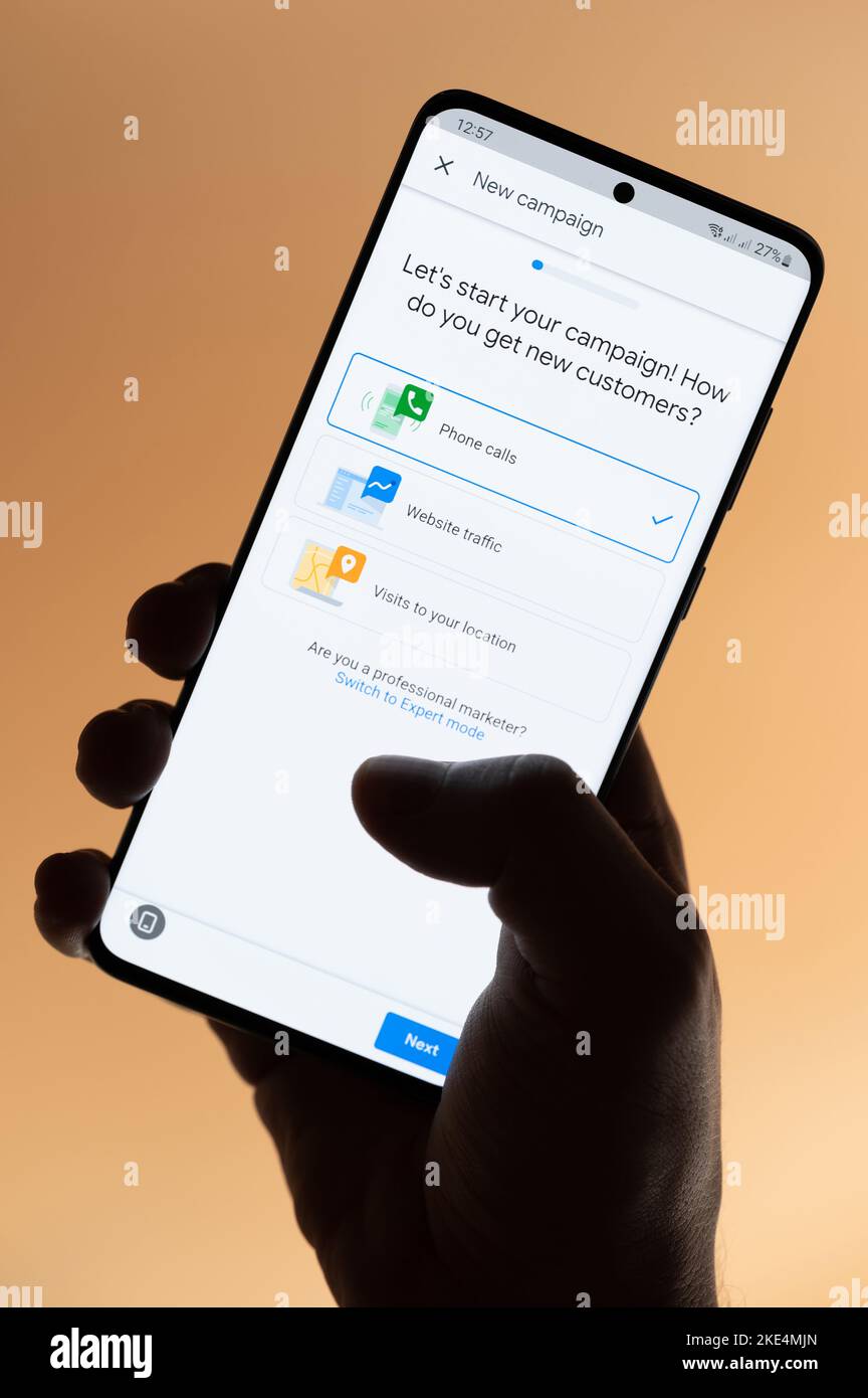 New york, USA - 4. November 2022: Erstellung einer neuen google-Werbekampagne auf dem Smartphone, das auf braunem Hintergrund isoliert in der Hand gehalten wird Stockfoto