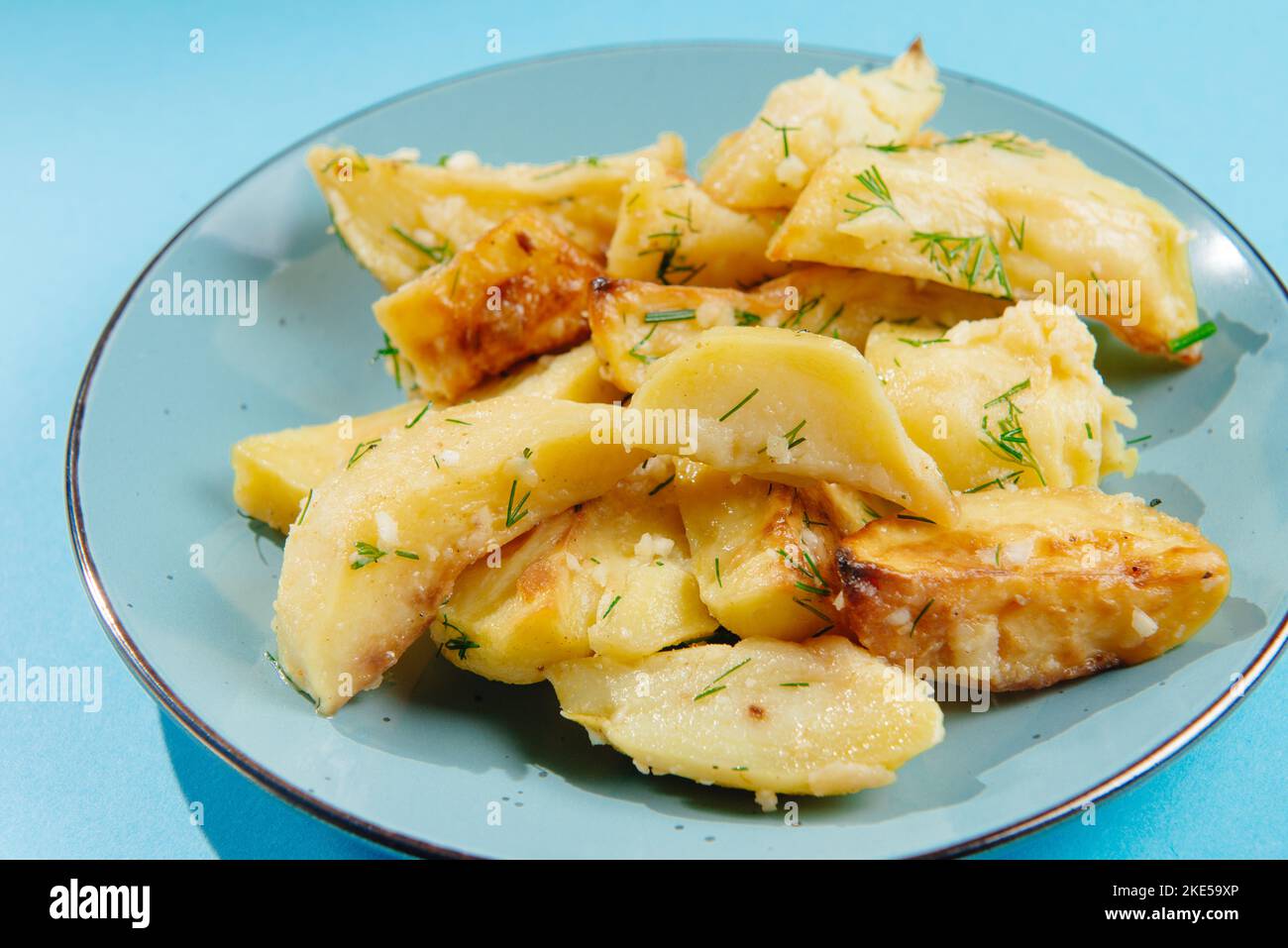 Gesunder Lebensstil, richtige Ernährung, Verbot ungesunder Lebensmittel.Bratkartoffeln auf einem Teller auf blauem Hintergrund, Leerstelle für Text.Stoppt verbotene Lebensmittel. Stockfoto