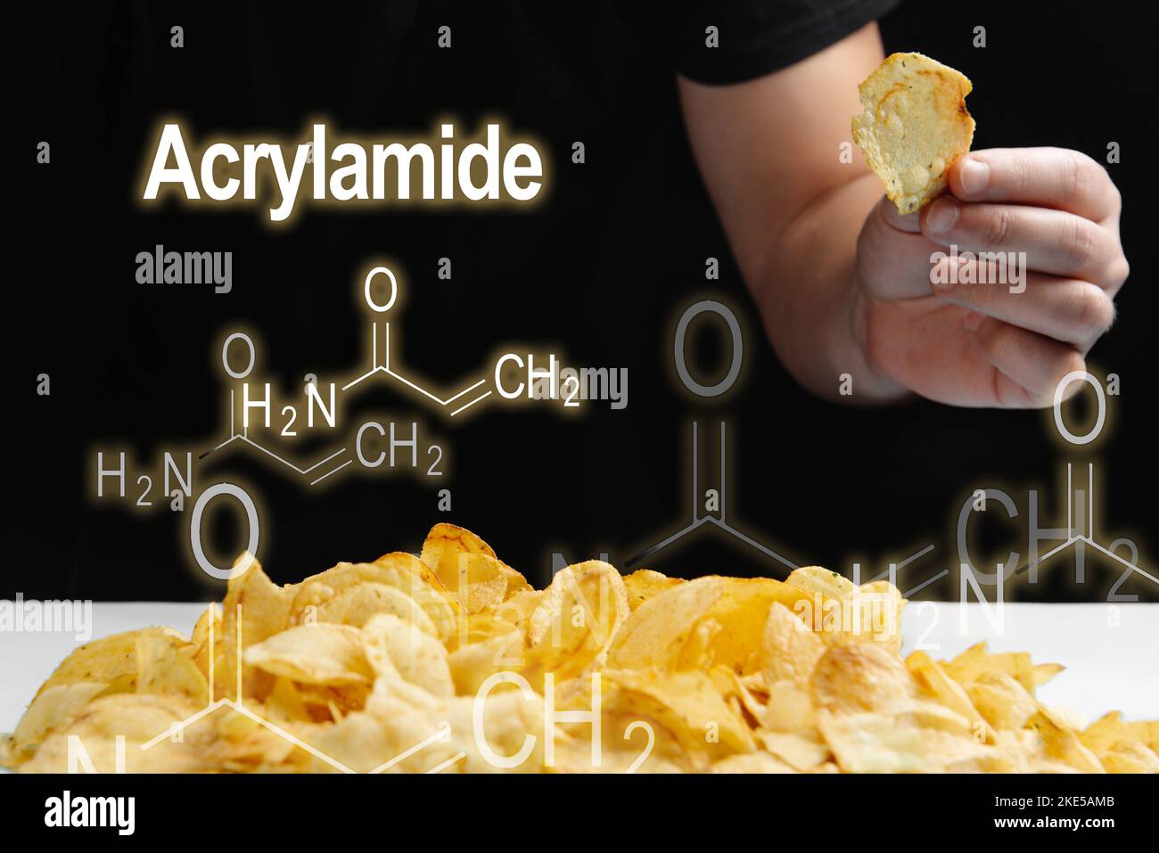 Mann isst frittierte Lebensmittel, Chips hoch in Acrylamid. Acrylamidformel auf schwarzem Hintergrund Stockfoto