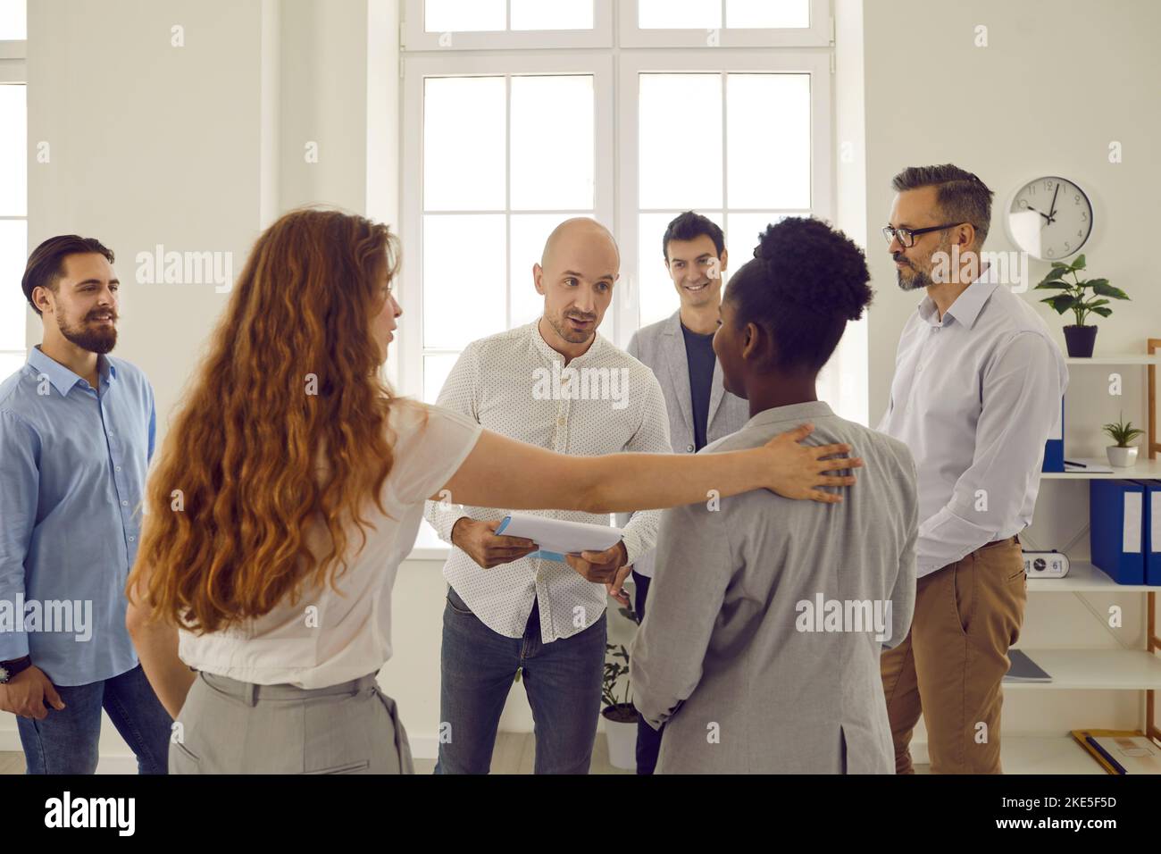 Korporative Business-Training im Büro mit Menschen in Runde stehen und zuhören Mann Kollegen. Stockfoto
