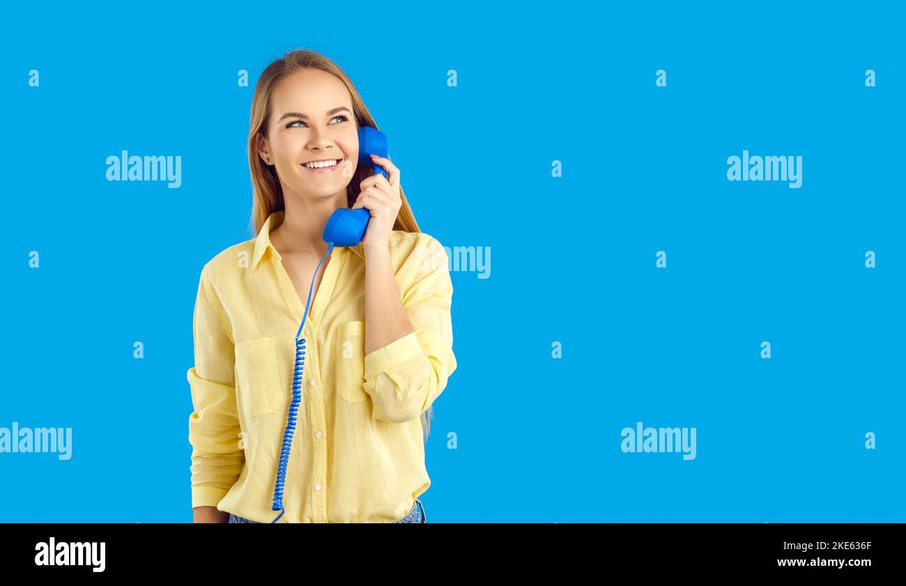 Lächelnde Frau spricht auf dem Festnetztelefon mit Unterstützung Stockfoto