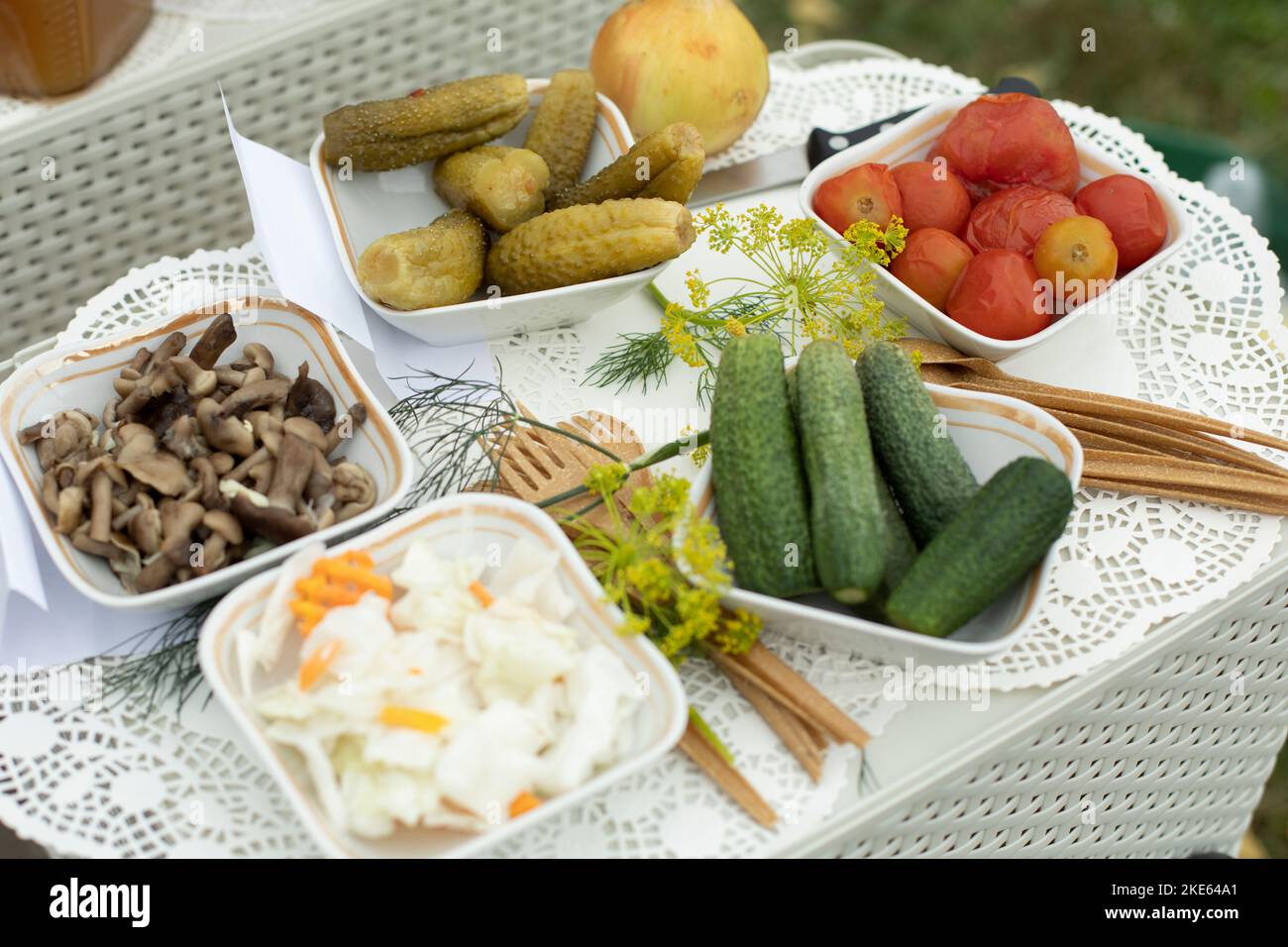 Essen auf dem Tisch. Gurken aus dem Garten. Gurken und Tomaten auf Tellern. Herzhaftes Mittagessen. Stockfoto