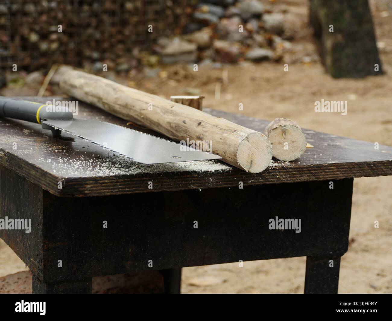 Scharfe Handsäge, Bügelsäge und Holzrohling auf der Werkbank Stockfoto