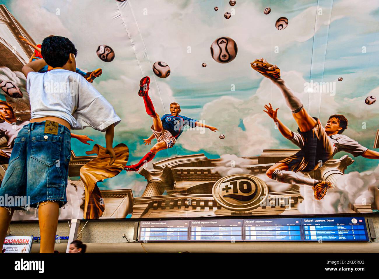 Deckenmalerei mit Fußballszenen am Hauptbahnhof, Köln, Deutschland. Während der FIFA Fußball-Weltmeisterschaft 2006. Auf einer Fläche von mehr als 800 Quadratmetern hat Adidas ein Fresko an der Decke des Kölner Hauptbahnhofs installieren lassen. In originalgetreuem antikem Look schweben Nationalspieler wie Michael Ballack, David Beckham, Zinédine Zidane und Juan Román Riquelme hoch über den Köpfen der Passanten. Stockfoto