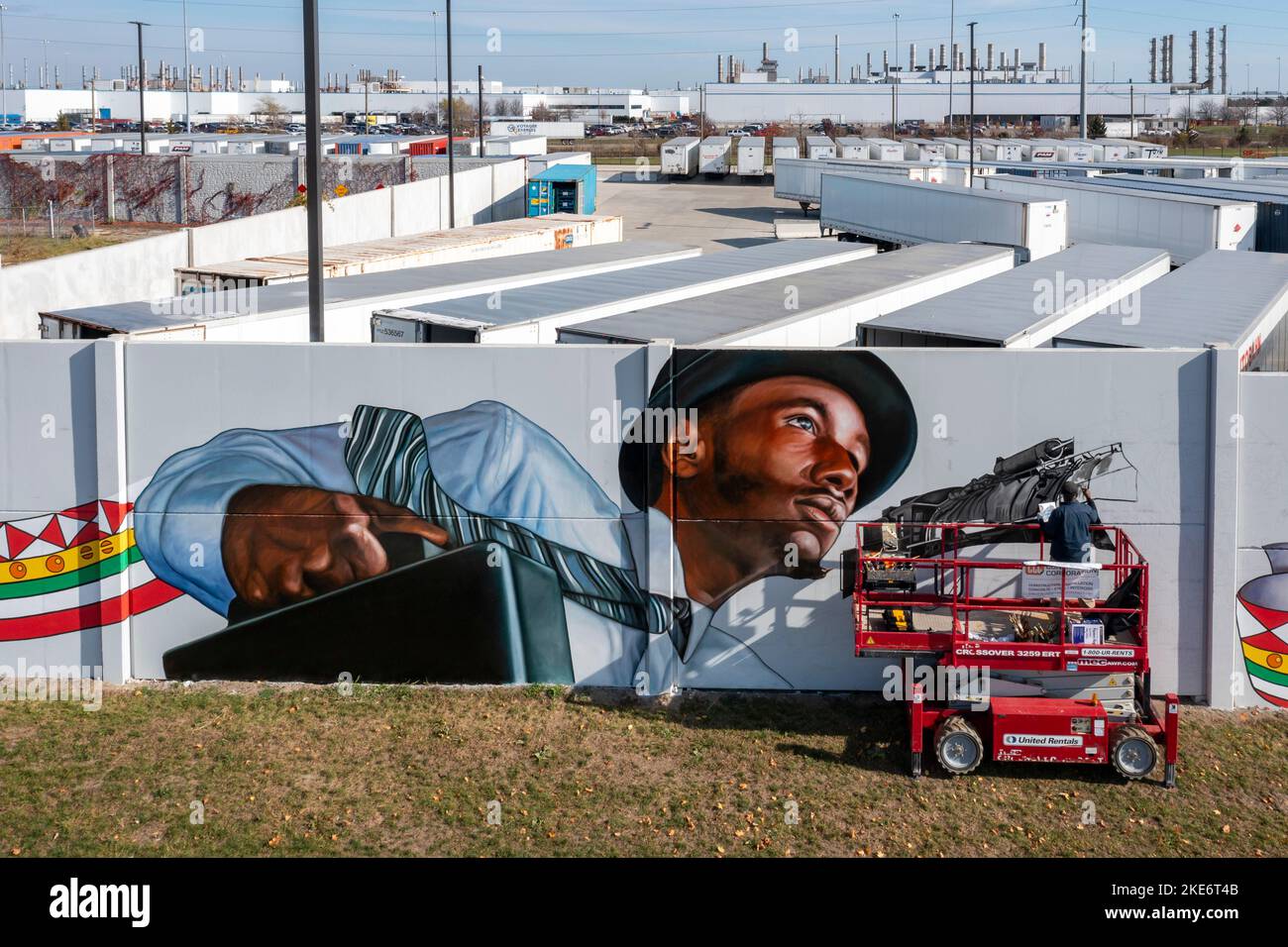 Detroit, Michigan - Hubert Massey arbeitet an der Bemalung eines blocklangen Wandbildes auf der Schallmauer rund um die Stellantis Jeep-Pflanze. Dieser Abschnitt der Mura Stockfoto