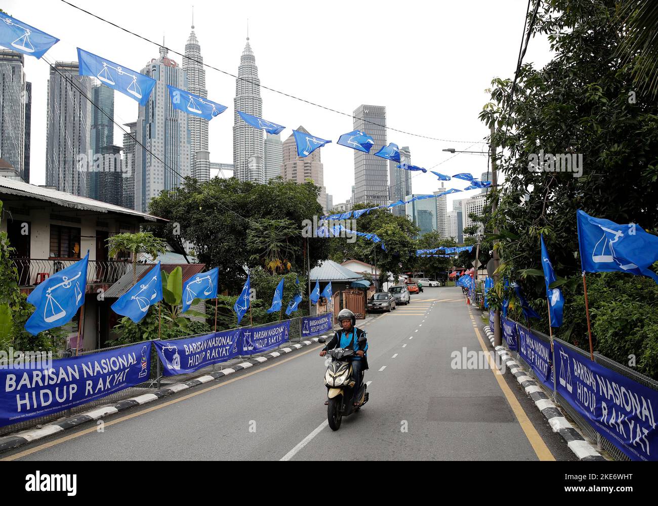 Ein Motorradfahrer fährt während der Parlamentswahlen in Kuala Lumpur an den politischen Parteiflaggen des National Front oder Barisan Nasional vorbei. Stockfoto