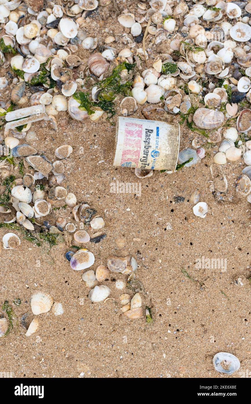 Meeresschutt - alter Einweg-Kunststoff-Joghurttopf, der am Strand gewaschen wurde - Kent, England, Großbritannien Stockfoto