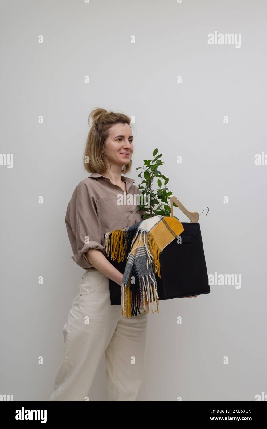 Glückliche entlassene Frau, die mit einer Kiste voller Sachen auszieht. Stockfoto