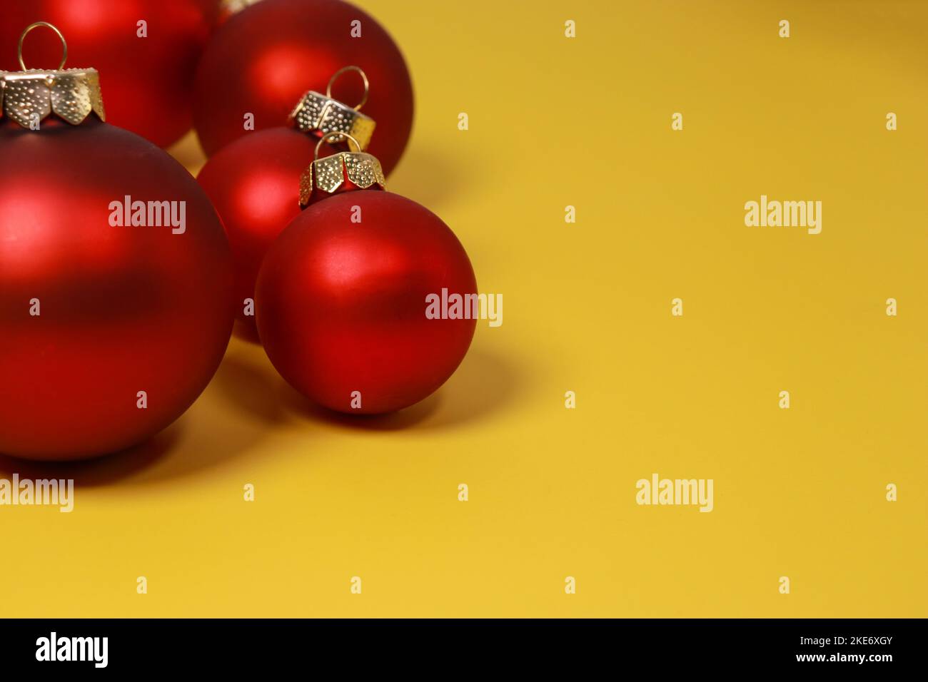 Rote Weihnachtskugeln auf gelbem Hintergrund. Flach liegend, Draufsicht, Kopierbereich Stockfoto