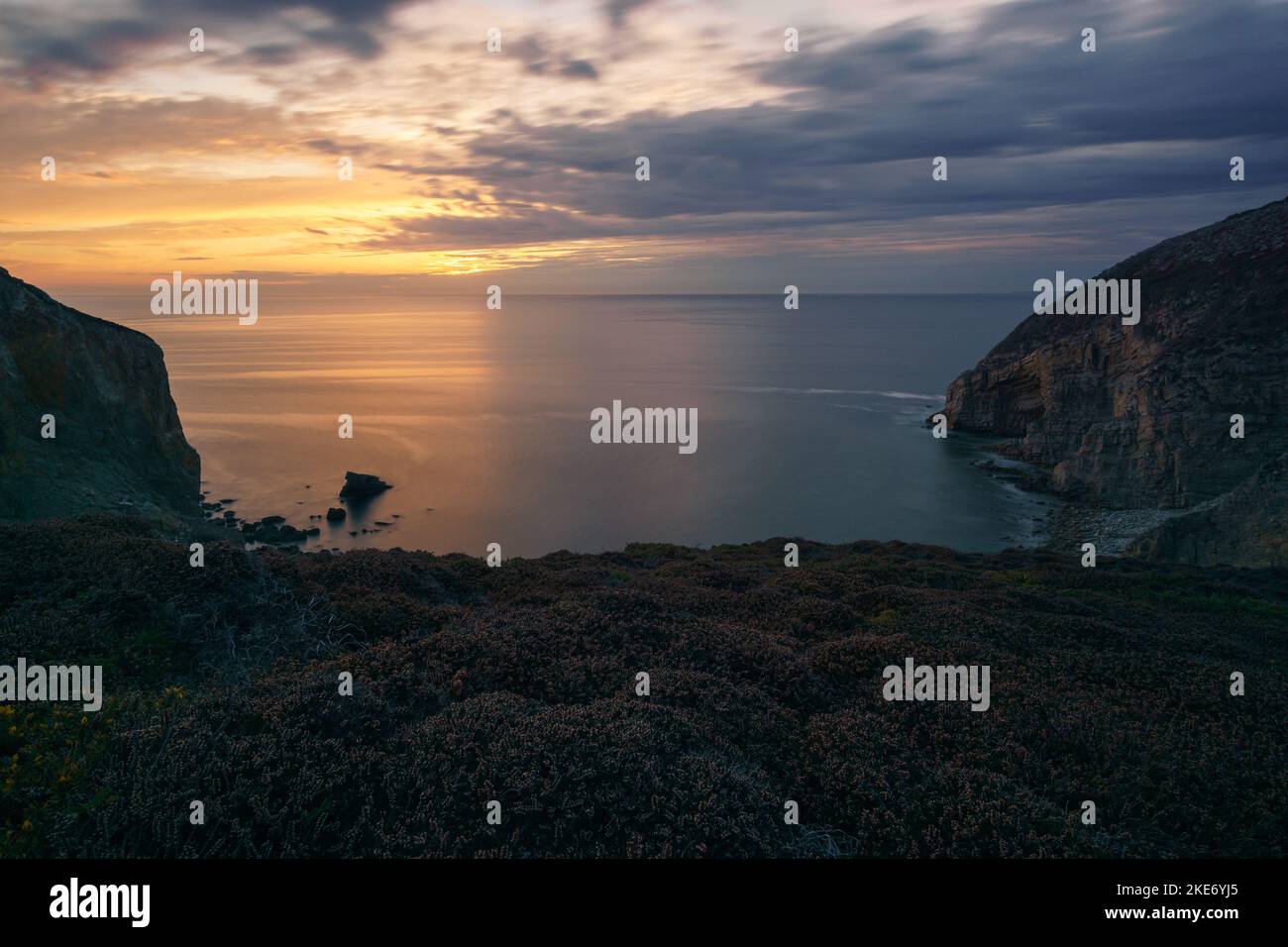 Lange Exposition der Küste in der Nähe von Cap de la Chevre mit Heidekraut bedeckt Landschaft bei Sonnenuntergang, Crozon, Parc naturel regional d'Armorique Bretagne, Frankreich Stockfoto