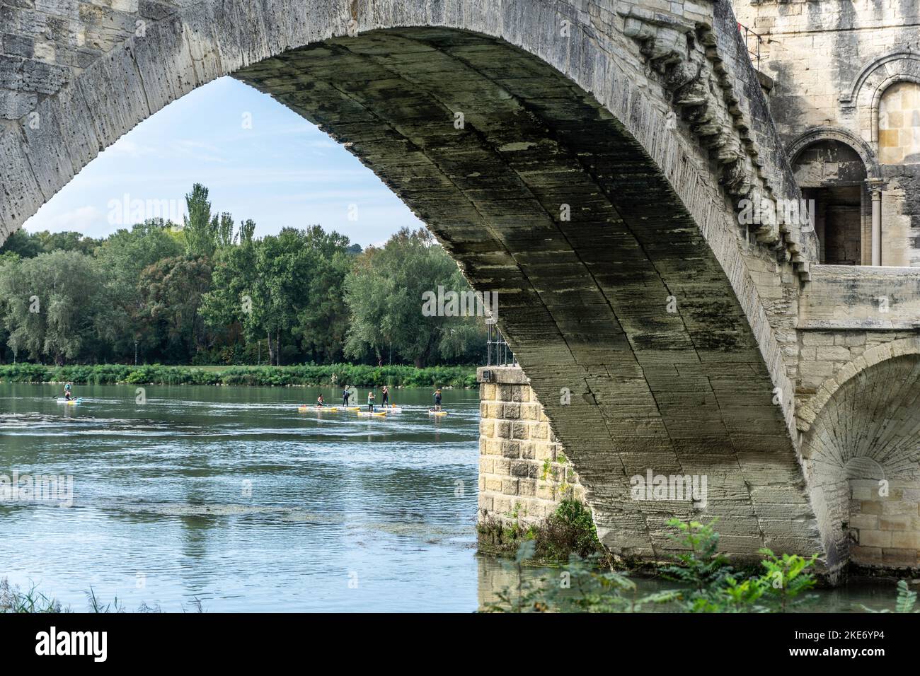 Surfboarder auf der Rhone in Avignon, Frankreich. Blick durch einen Bogen der Brücke Saint Bénézet. Stockfoto