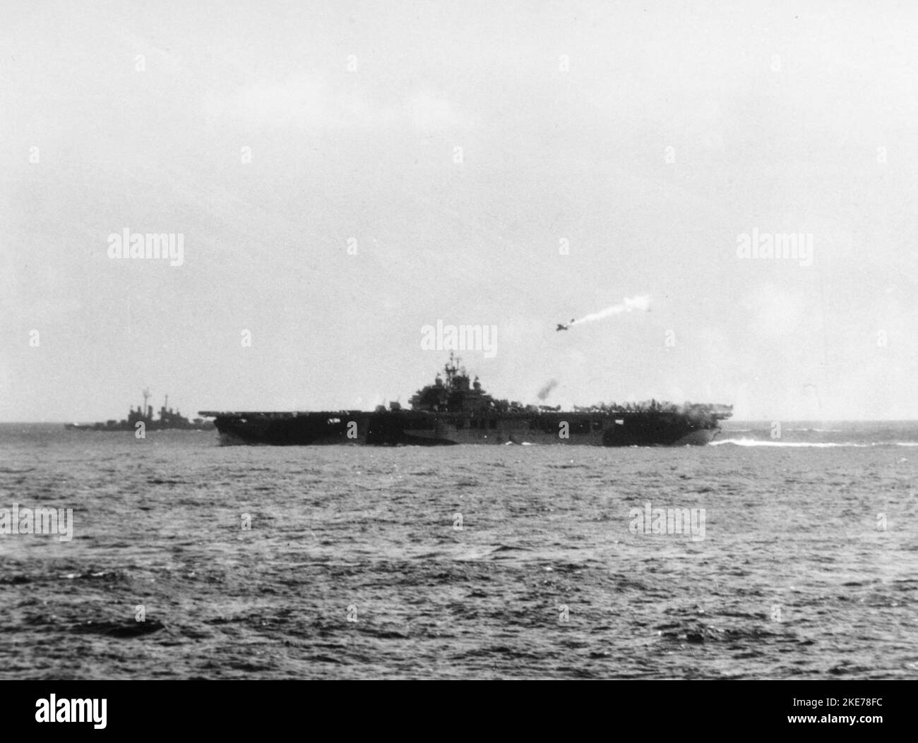 Der US Navy-Flugzeugträger USS Essex (CV-9) wird während des Angriffs auf Kamikaze am 25. November 1944 von einem japanischen Yokosuka D4Y 'Judy'-Flugzeug getroffen. Stockfoto