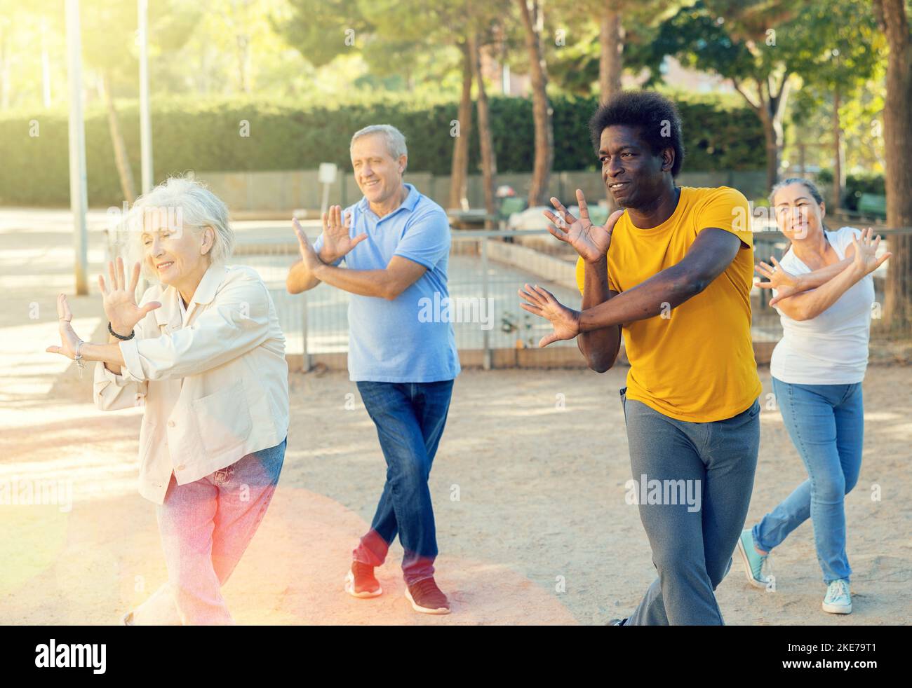 Gruppe von multirassischen Freunden, die sich im Freien treffen und einfache Bewegungen an einem sonnigen Herbsttag tanzen Stockfoto