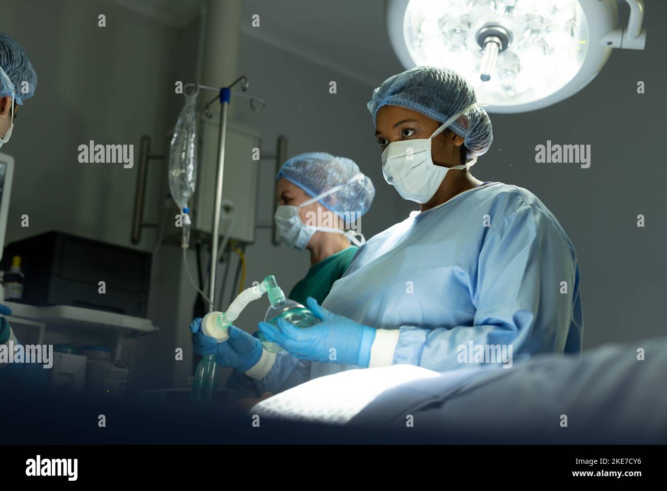 Zwei unterschiedliche Chirurgietechnikerinnen bereiten Geräte im Operationssaal während der Chirurgie vor Stockfoto