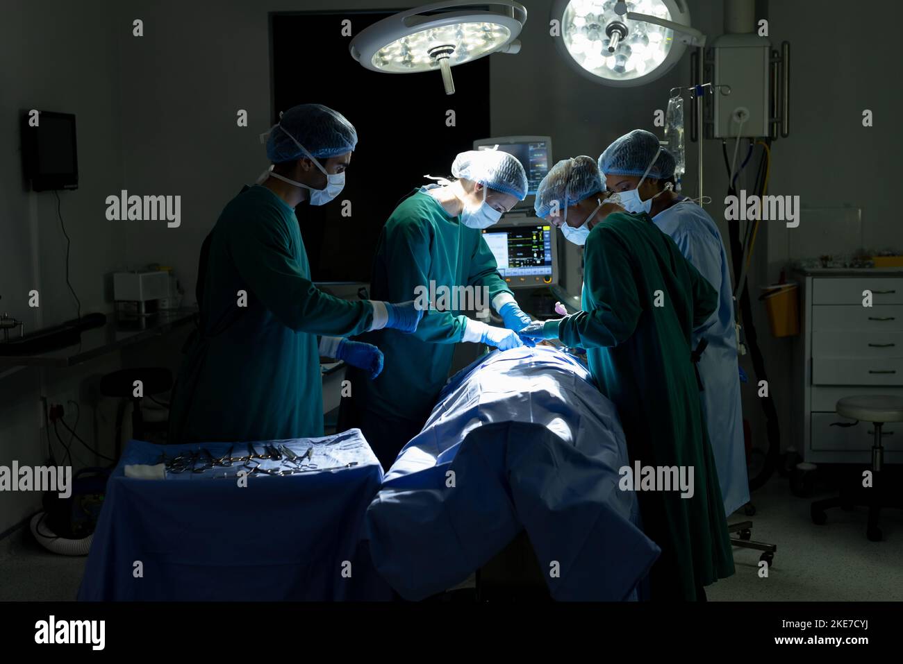 Vielfältige Gruppe von Operationstechnikern und Chirurgen, die Patienten im Operationssaal operieren, mit Kopierraum Stockfoto
