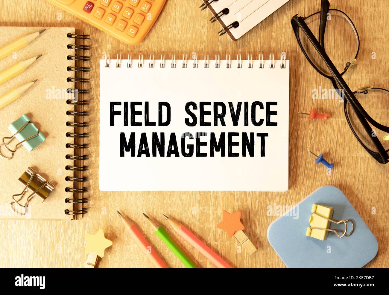 Auf hellblauem Hintergrund helle Holzblöcke und Würfel mit dem Text FSM Field Service Management. Stockfoto