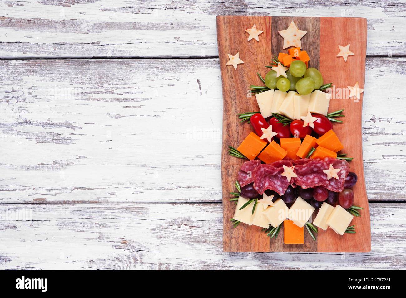 Weihnachtsbaum Charcuterie Board. Blick über einen weißen Holzhintergrund. Auswahl an Käse- und Fleischgerichten. Stockfoto