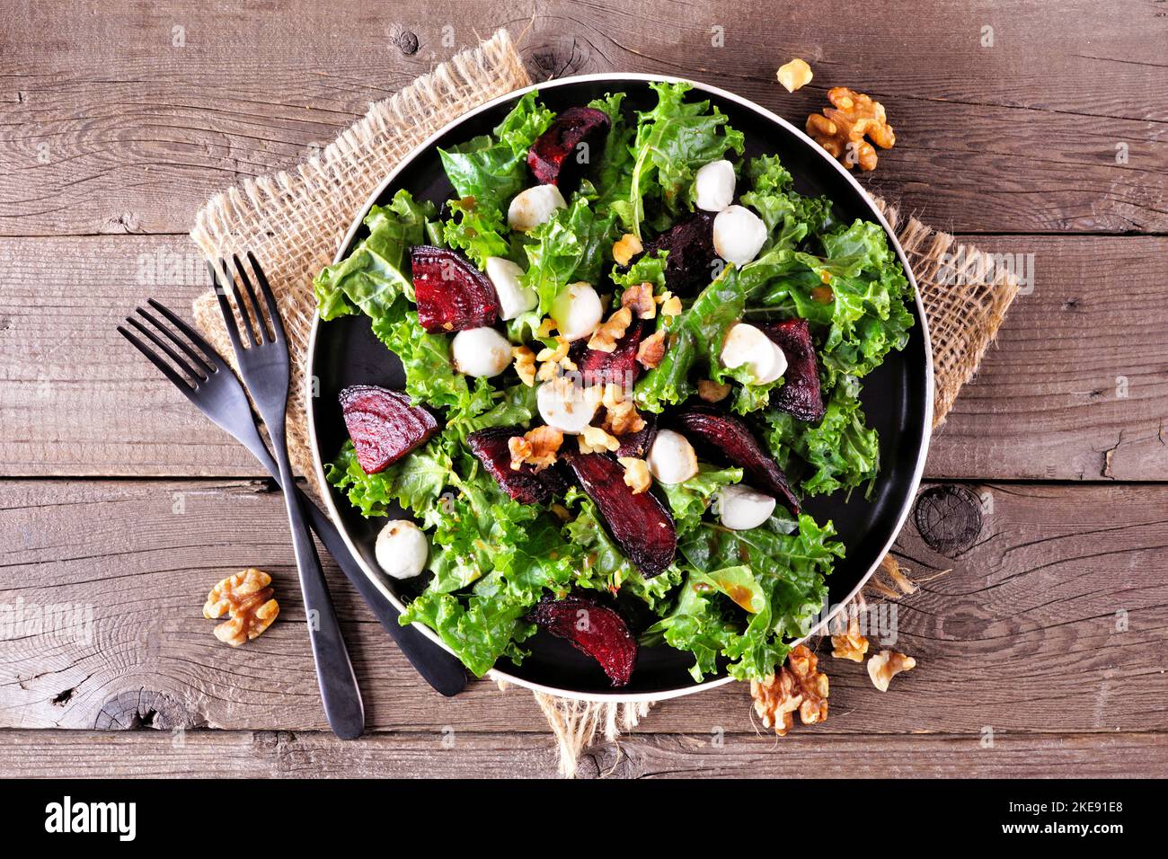 Gesunder Grünkohl- und Rübensalat mit Käse und Walnüssen. Oben Ansicht Tischszene über einem rustikalen Holz Hintergrund. Stockfoto