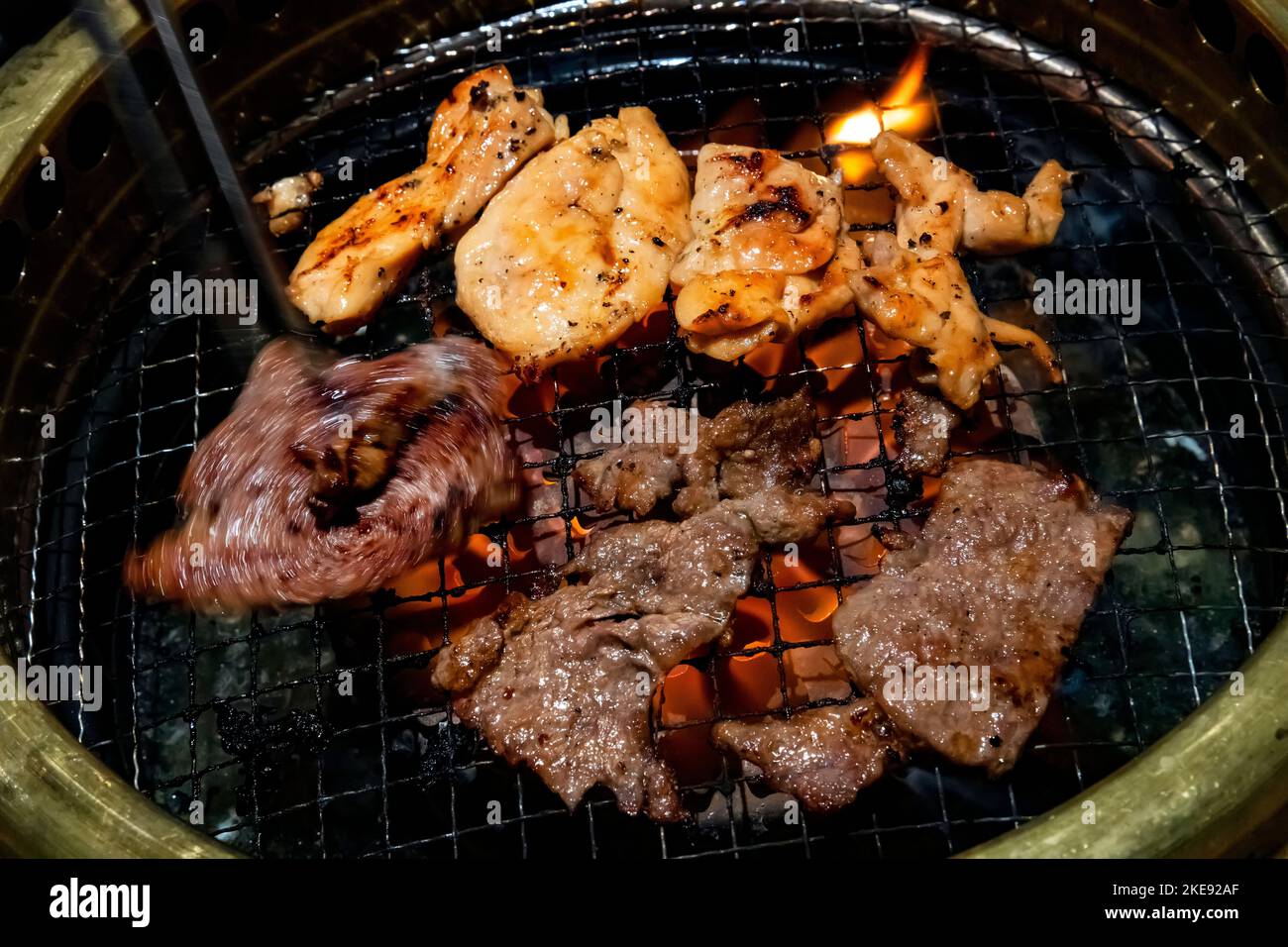 Koreanisches BBQ-Restaurant, Grillen von Huhn und Rindfleisch. Stockfoto