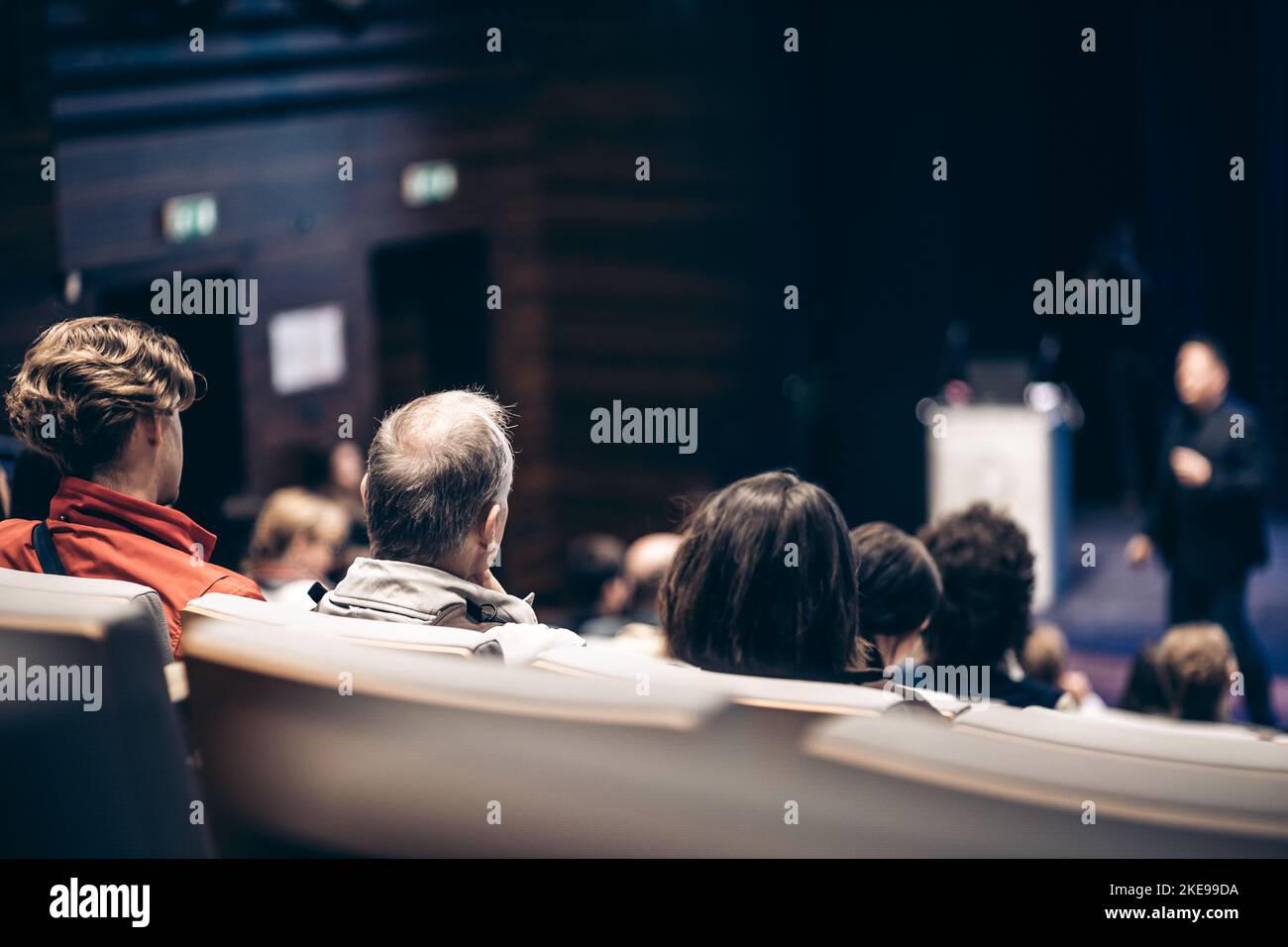 Referent, der bei einer Geschäftsveranstaltung im Konferenzsaal spricht. Rückansicht von nicht erkennbaren Personen im Konferenzsaal. Business und Entrepreneurship Konzept Stockfoto