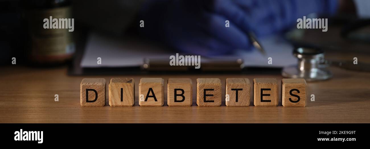 Arzt Endokrinologe schreiben Rezept auf dem Hintergrund von Holzwürfeln mit Wort Diabetes Nahaufnahme Stockfoto