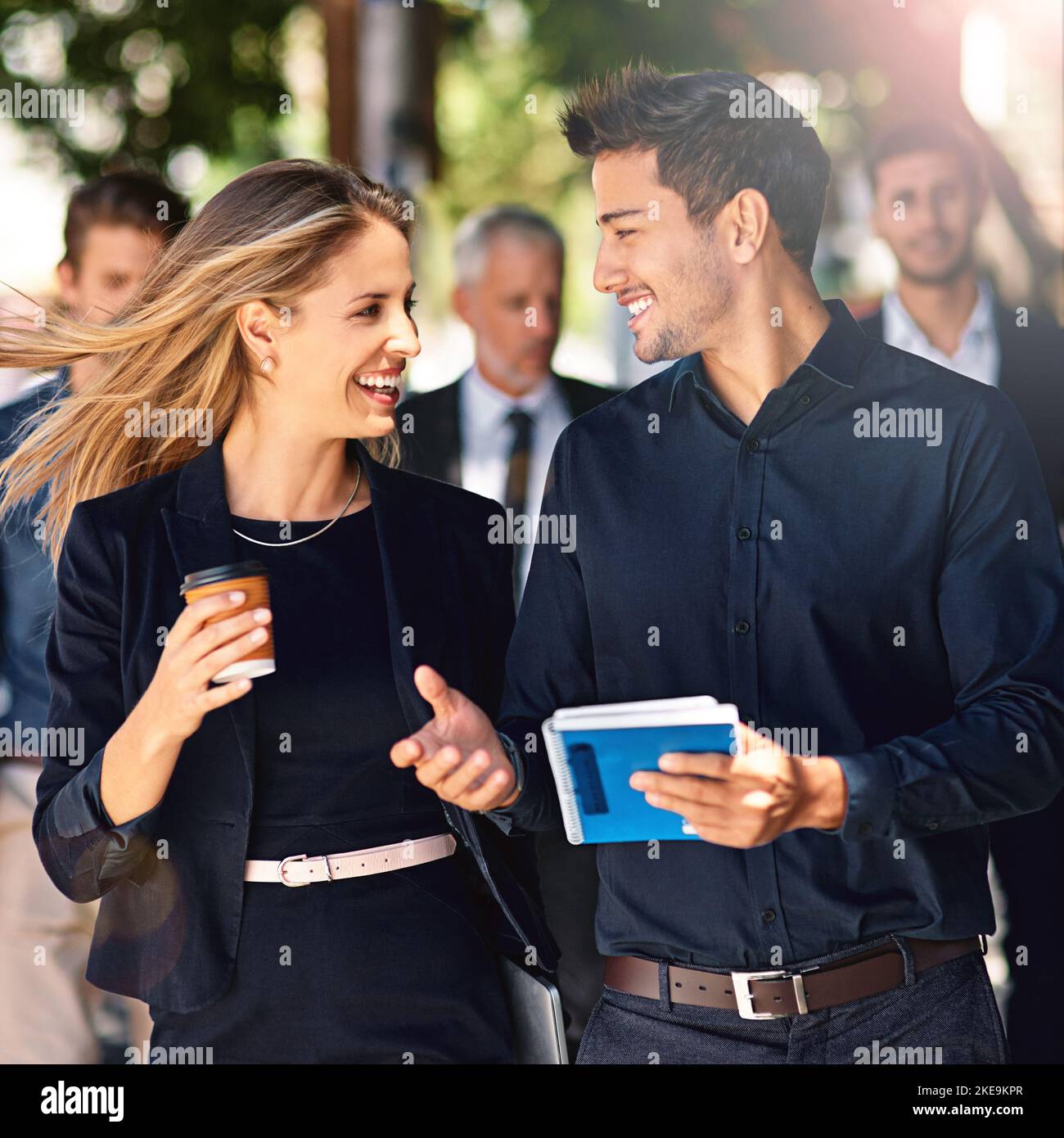 Mit ihrem Geschäft auf die Straße. Kollegen in Unternehmen, die eine Diskussion führen, während sie die Straße entlang gehen. Stockfoto