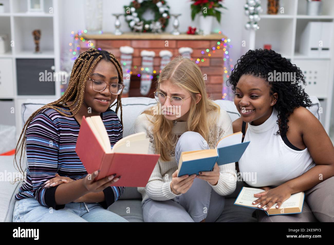 Lustige Informationen, die ein Student in einem Buch gelesen hat. Afrikanische Frauen und eine europäische Frau. Stockfoto