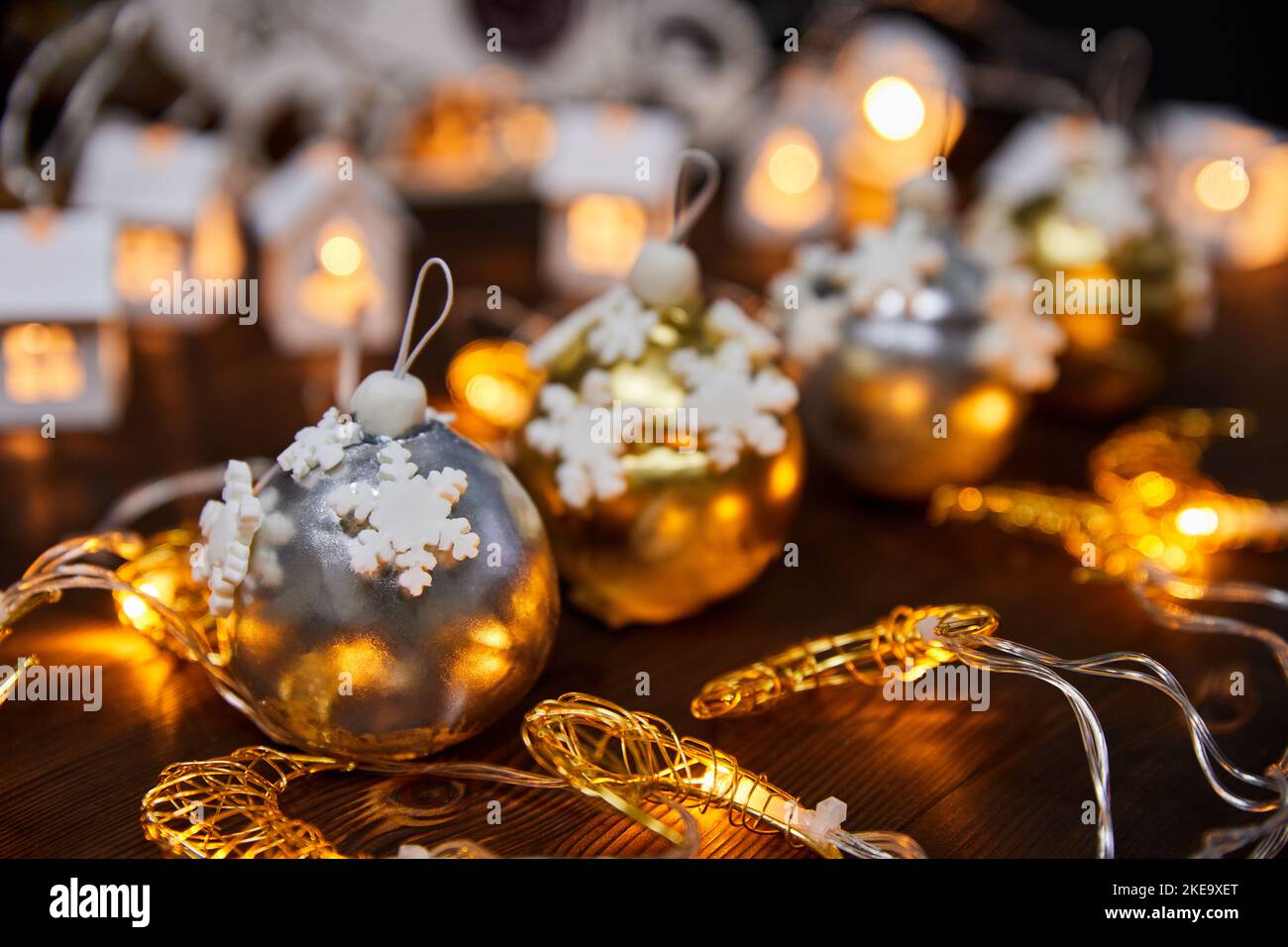 Weihnachtskuchen in Form von Mousse-Kugeln auf einem Hintergrund glühender Girlanden Stockfoto