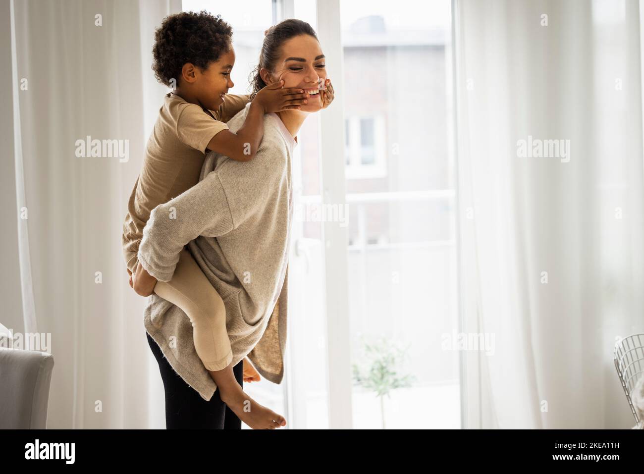 Frau und Sohn Huckepack-Fahrt Stockfoto
