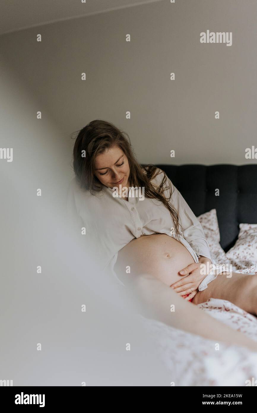 Schwangere Frau sitzen im Bett Stockfoto