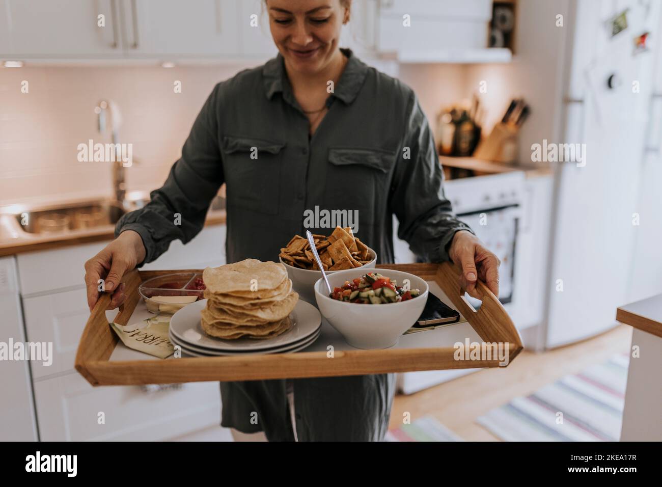 Frau trägt Tablett mit Essen Stockfoto