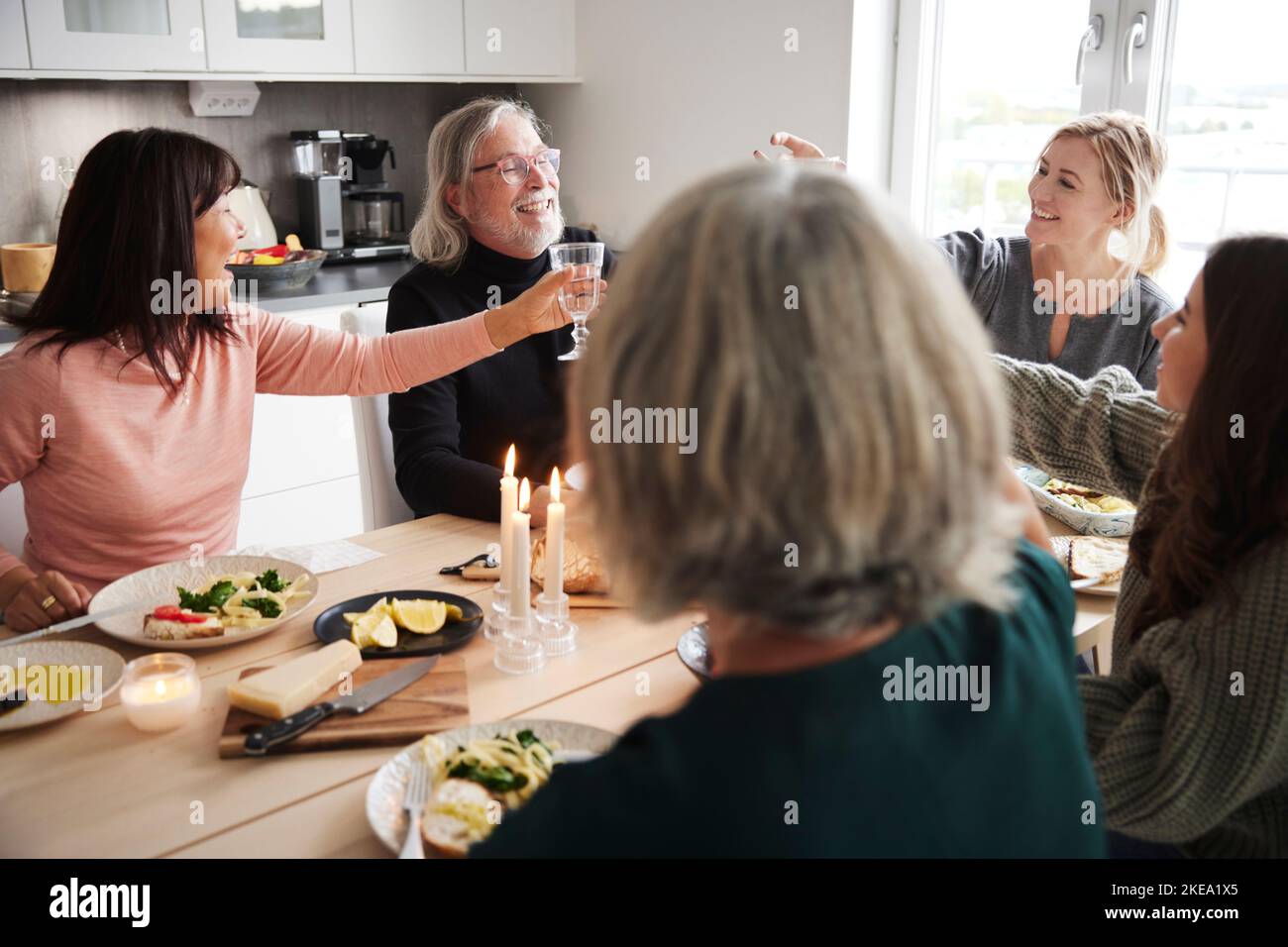 Die Familie rastet beim Abendessen Toast auf Stockfoto