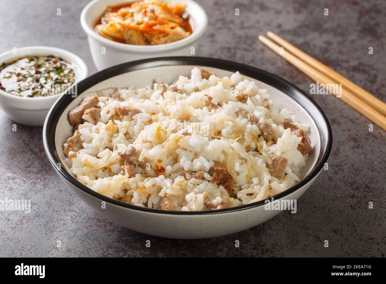 Koreanische Küche kongnamul bap Reis mit Sojabohnen und Fleisch serviert mit Yangnyumjang Sauce und Kimchi close-up auf dem Tisch. Horizontal Stockfoto