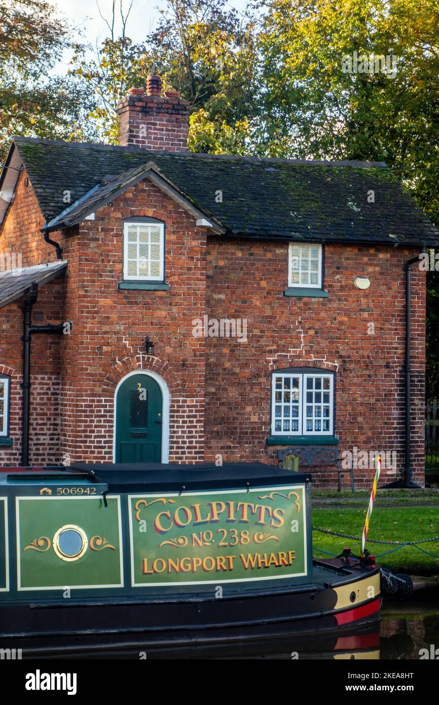 Alte funktionierende Kanalschromper von Longport Wharf vertäuten auf dem Shropshire Union Kanal vor einem Kanalhaus in Nantwich Chethire Stockfoto